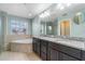 Bright bathroom features a double vanity, granite counters, soaking tub, and walk-in shower at 5144 Ravena E Ave, St Cloud, FL 34771
