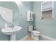 Powder room featuring a pedestal sink, decorative mirror, cabinet and natural light at 5144 Ravena E Ave, St Cloud, FL 34771