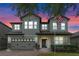 Charming two-story home featuring a brick driveway and a well-manicured lawn against a vibrant sunset backdrop at 5144 Ravena E Ave, St Cloud, FL 34771