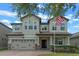 Two-story home showcasing a brick driveway, a well-manicured lawn, and a charming two-car garage at 5144 Ravena E Ave, St Cloud, FL 34771