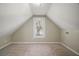 A cozy attic space with neutral colors and a single window, perfect for storage or a quiet retreat at 519 N Clara Ave, Deland, FL 32720