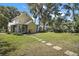 Expansive backyard with lush grass, a stepping stone pathway, and mature trees at 519 N Clara Ave, Deland, FL 32720