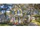 Inviting two-story yellow house with blue shutters, a welcoming porch, and mature landscaping at 519 N Clara Ave, Deland, FL 32720