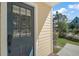 Close-up of the front door showcasing a window and yellow siding, complemented by lush greenery at 519 N Clara Ave, Deland, FL 32720