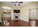 Cozy living room showcasing hardwood floors, a brick fireplace, and ample natural light at 519 N Clara Ave, Deland, FL 32720