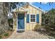 Cozy outbuilding with a blue door and window, complemented by a brick pathway and surrounding greenery at 519 N Clara Ave, Deland, FL 32720