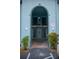View of a charming building entrance with an arched entryway and stairway leading to the upper level units at 5220 Curry Ford Rd # 303, Orlando, FL 32812