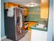 Galley kitchen featuring a stainless steel refrigerator, wood cabinets, and tiled walls at 5220 Curry Ford Rd # 303, Orlando, FL 32812