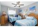 Charming bedroom featuring twin beds, coastal decor, wood floors, and a ceiling fan at 5502 Willow Bend Trl, Kissimmee, FL 34758