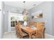 A dining room with a wooden table, six chairs, and a beach-themed decor at 5502 Willow Bend Trl, Kissimmee, FL 34758