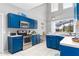 Bright kitchen featuring blue cabinets, stainless steel appliances, and white tile flooring at 5502 Willow Bend Trl, Kissimmee, FL 34758