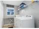 Efficient laundry room with a modern washer and dryer, shelving, and natural light from a window at 5502 Willow Bend Trl, Kissimmee, FL 34758