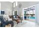 Bright living room with tile floors, leather sofas, and a view of the pool at 5502 Willow Bend Trl, Kissimmee, FL 34758
