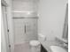 Bathroom featuring marble-look tile, dark vanity, granite countertop, glass shower, and modern fixtures at 6038 Sw 154Th Place Rd, Ocala, FL 34473