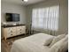Cozy bedroom featuring a dresser with a television and a bright window with sheer curtains at 6104 Topher Trl # 6104, Mulberry, FL 33860
