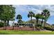 Exterior view of the Fairwoods community sign with landscaping and palm trees, set against a blue sky at 6104 Topher Trl # 6104, Mulberry, FL 33860