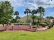 Fairwoods community sign surrounded by lush landscaping and mature palm trees, with building in the background at 6104 Topher Trl # 6104, Mulberry, FL 33860