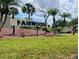 Community sign for Fairwoods surrounded by well-kept landscaping and mature palm trees on a sunny day at 6104 Topher Trl # 6104, Mulberry, FL 33860