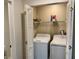 Bright laundry room with white washer and dryer set, storage shelf, and louvered closet doors at 6104 Topher Trl # 6104, Mulberry, FL 33860