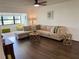 Open concept living room with hardwood floors, a large comfortable sectional, and bright sunlight at 6104 Topher Trl # 6104, Mulberry, FL 33860