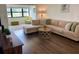 Inviting living room features a large sectional sofa, wood floors, and natural light from a bright window at 6104 Topher Trl # 6104, Mulberry, FL 33860