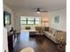 Spacious living room with hardwood floors, large sectional, and bright light from sunroom at 6104 Topher Trl # 6104, Mulberry, FL 33860