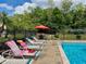 Community swimming pool featuring lounge chairs, tables with a large sun umbrella, and plenty of green space at 6104 Topher Trl # 6104, Mulberry, FL 33860