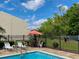 Community swimming pool with tables and chairs under an umbrella, and plenty of green space for relaxation at 6104 Topher Trl # 6104, Mulberry, FL 33860