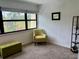 Sitting area with green armchair and storage ottoman, showcasing neutral carpet and view to the outdoors at 6104 Topher Trl # 6104, Mulberry, FL 33860