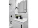 Stylish bathroom with a modern sink, mirror, marble tiled walls, and sleek black hardware at 6312 Appian Way, Orlando, FL 32807