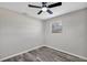 Bedroom featuring light gray walls, gray wood floors, a ceiling fan, and a window at 6312 Appian Way, Orlando, FL 32807