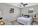Bedroom featuring light gray walls, gray wood floors, white bed, ceiling fan, and two windows at 6312 Appian Way, Orlando, FL 32807