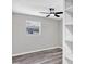 Bedroom featuring light gray walls, gray wood floors, ceiling fan, a window, and built in shelves at 6312 Appian Way, Orlando, FL 32807