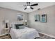 Bedroom featuring light gray walls, gray wood floors, ceiling fan, two side tables with lamps, and a bed at 6312 Appian Way, Orlando, FL 32807