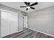 Bedroom featuring light gray walls, gray wood floors, a closet, ceiling fan, and an open door at 6312 Appian Way, Orlando, FL 32807