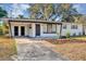 Charming single-story home featuring a covered carport and freshly landscaped front yard with flowers at 6312 Appian Way, Orlando, FL 32807