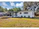 Charming single-story home featuring a covered carport and freshly landscaped front yard with flowers at 6312 Appian Way, Orlando, FL 32807
