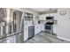 Kitchen featuring stainless steel appliances, white cabinets and drawers, gray wood floors, and light gray walls at 6312 Appian Way, Orlando, FL 32807