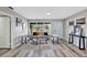 Bright living room with a large window, light gray walls, gray wood floors, and minimal furniture at 6312 Appian Way, Orlando, FL 32807