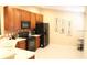 Kitchen features cherry cabinets, black appliances, tile backsplash, and tile flooring at 6453 Alcalde Ct # 104, Orlando, FL 32835
