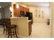 Eat-in kitchen features cherry cabinets, black appliances, tile backsplash and unique wall decor at 6453 Alcalde Ct # 104, Orlando, FL 32835