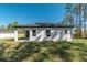 Rear exterior view of a modern home with well-maintained lawn and landscaping at 7110 Sw 134Th St, Ocala, FL 34473