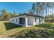 Back exterior view of home with a screened in porch and well-maintained lawn at 7110 Sw 134Th St, Ocala, FL 34473