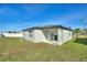 Exterior view of the backyard with a covered patio and well-manicured lawn at 804 Colville Dr, Kissimmee, FL 34759