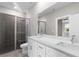 Bathroom with dual sink vanity, quartz countertop, glass shower, and view to main bedroom at 804 Colville Dr, Kissimmee, FL 34759