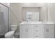Bathroom boasts dual sink vanity, sleek white cabinetry, and glass shower, all illuminated by ample natural light at 804 Colville Dr, Kissimmee, FL 34759
