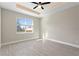 Bright bedroom featuring wood-style tile flooring, tray ceiling with fan, and a large window offering abundant natural light at 804 Colville Dr, Kissimmee, FL 34759