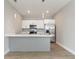 Stylish kitchen with white cabinets, stainless steel appliances, and a kitchen island with breakfast bar at 804 Colville Dr, Kissimmee, FL 34759