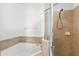 A well-lit bathroom offers a shower and bathtub with tile surround at 819 Featherstone Ln, Lake Mary, FL 32746