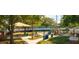A sunny playground including picnic tables, a green lawn and mature shade trees at 819 Featherstone Ln, Lake Mary, FL 32746
